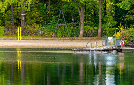 Den See an der Badeanstalt im Volkspark Jungfernheide im Herbst, im Bild sind die Schwimmleinen mit Boje Abgrenzungen vom See zum Schwimmbad zu erkennen, Berlin-Charlottenburg, Deutschland