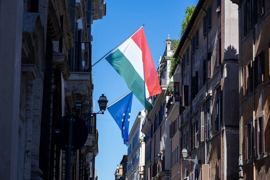 Hungarian and European Union flags hanging over a historic street in the centre of Rome, Italy
