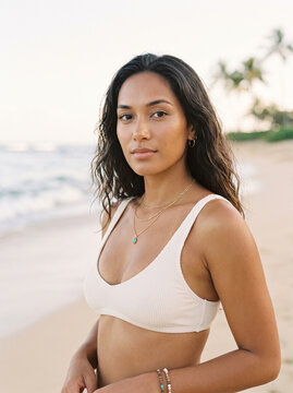 portrait of a woman in swimwear poised on a beach