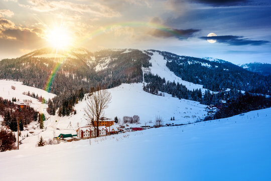 beautiful countryside of Ukraine. day meet night. sun and moon over wonderful winter landscape in mountains. snow covered field and rolling hills. rural scenery at twilight