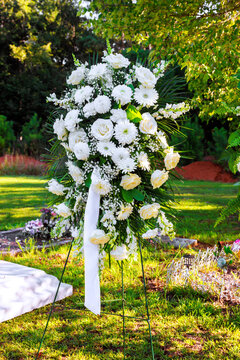 White flowers are set in stand at cemetery memorial area on burial service