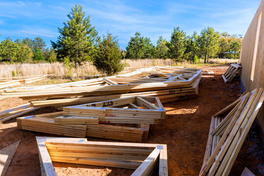 Workers are preparing wooden beams frames, roofing joins at construction site with assemble new house