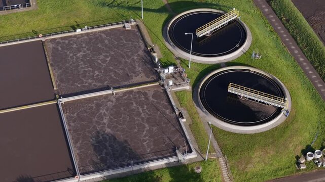 Aerial view of sewage treatment plant aeration basins and circular clarifier tanks