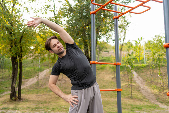 Man perform side stretch at outdoor fitness area