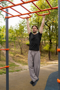 Man perform pull-up exercise at outdoor fitness area