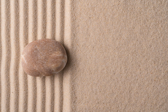 Zen meditation stone on raked sand