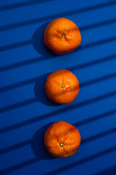 Three mandarins citrus fruit on blue background