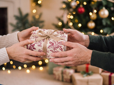 Family exchange Christmas gift at home by decorated tree