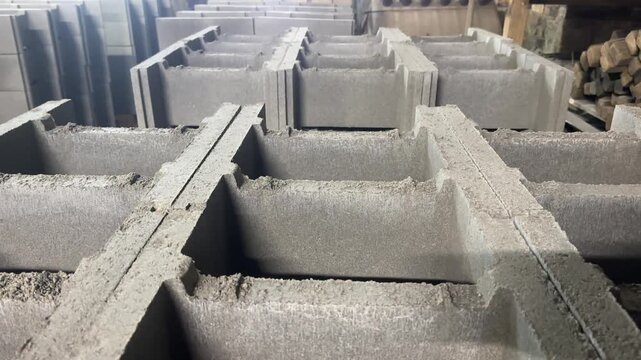 Close-up view of grey concrete hollow masonry blocks stacked in a warehouse.