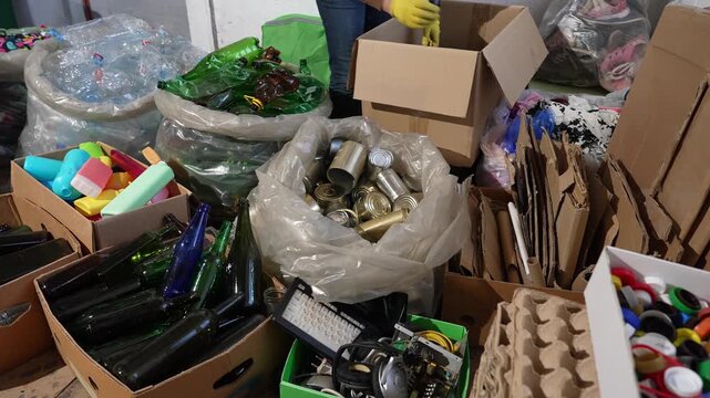 Individual sorting waste for recycling by separating plastic, paper, glass, metal, textile and electronic devices into designated bins. Sustainability and environmental responsibility