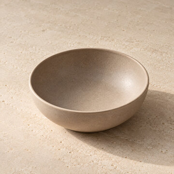 Empty Matte Beige Ceramic Bowl on a Warm Sand-Colored Surface, Minimalist Tableware Product Photography
