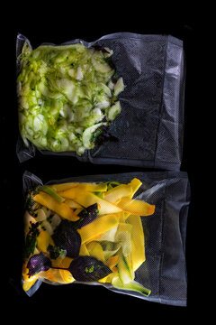 Cut Vegetables in Sealed Bags on a Black Surface