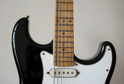music production and performance, electric guitar close up with black body and maple neck for rock and blues recording sessions in a studio setting