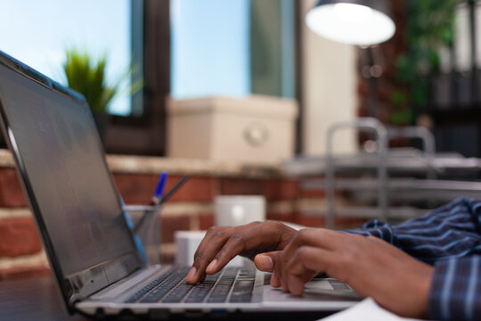 Typing, hands and keyboard in a close side view of fingers using a laptop at an office desk. Shallow focus and graphics on screen for digital tasks, data entry and business productivity.
