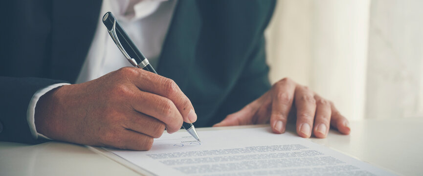 Banner Close up hand man colleagues meeting mergers and acquisitions business. Banner Two Businessman signing contract document dealing teamwork. Partners Signed document at office with copy space