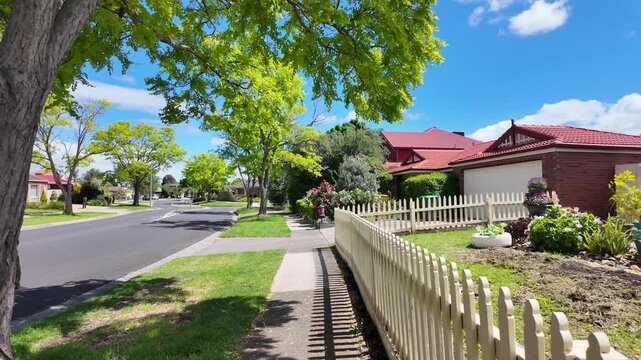 A quiet residential street in Hoppers Crossing, Melbourne, Australia, with well-tended front garden, mature street trees, a concrete footpath and suburban road. A desirable and peaceful neighborhood