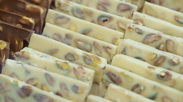 Rows of nougat bars with nuts displayed at a confectionery shop