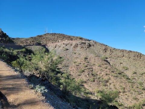 Desert road winding up North Mountain in Phoenix Arizona toward communication towers at the summit