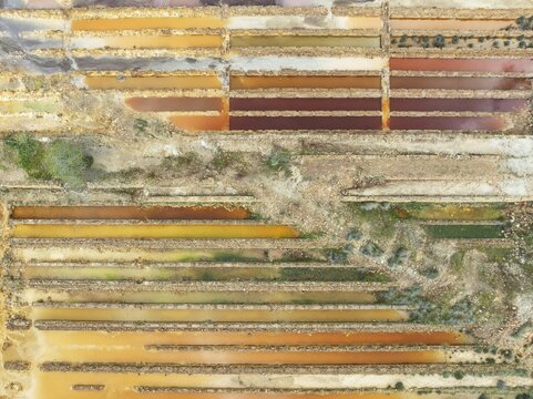 Abandoned saline ponds in the mineral-rich area of the Rio Tinto mines, hence the different colours caused by oxidised iron minerals. Aerial view. Drone shot. Huelva province, Andalusia, Spain