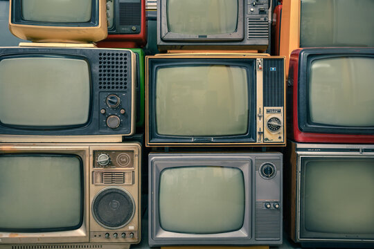 Old retro televisions pile and blank screen display, front view, close up