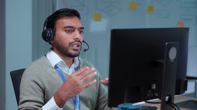 customer service agent male operator working computer wearing headset explaining online video call office