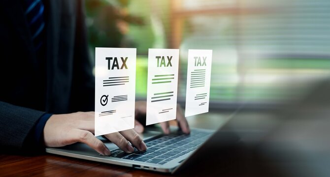 Business person typing on a laptop with glowing digital tax document icons and forms. Concept of tax return filing, financial accounting, compliance, and corporate business administration.