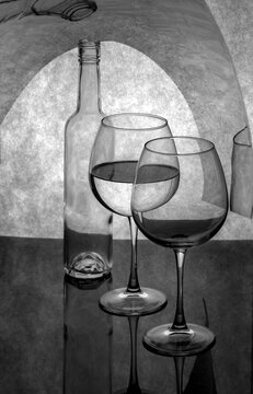 Still life with glasses and a bottle on a gray background