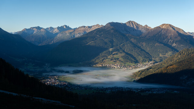 Blick von oben auf Ehrwald in Tirol mit Nebel im Tal und den Bergen im Hintergrund