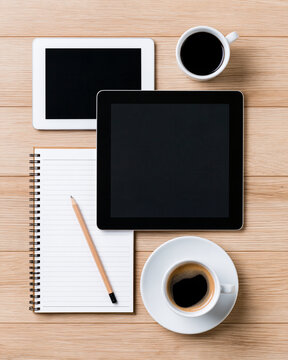 Online course preparation scene with a tablet displaying a generic abstract shape, a blank workbook, pencil and coffee cup, top-down view on a light oak desk, natural morning light, uncluttered