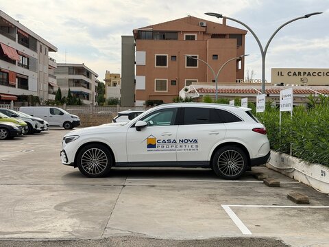 Mallorca, spain, october 10, 2026, white mercedes benz glc carrying casa nova properties branding, parked in an urban lot along avinguda del rei jaume i in calvia