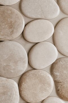 Japandi bathroom wall with rounded beige stone tiles creating a calm natural textured surface