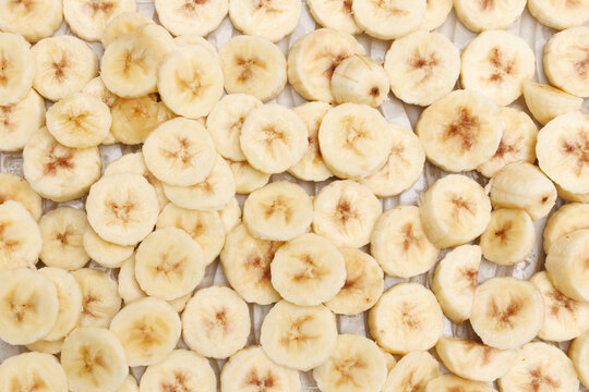 Fresh banana slices scattered on a light surface