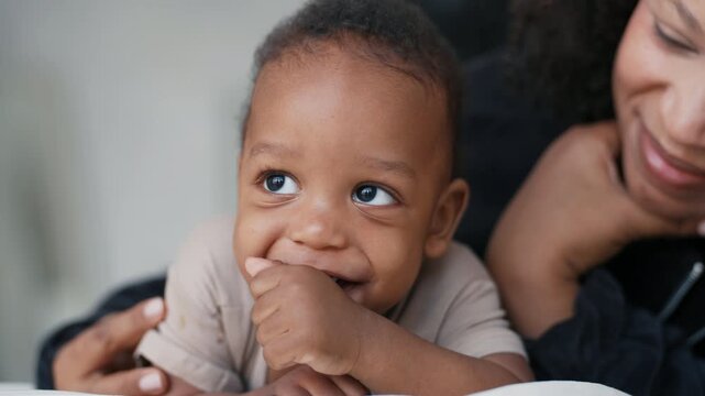 Closeup portrait of happy african baby, big black eyes in charming child face. Happy family with adopted baby, african american ethnicity, mixed race people, diversity and authenticity, smiling child