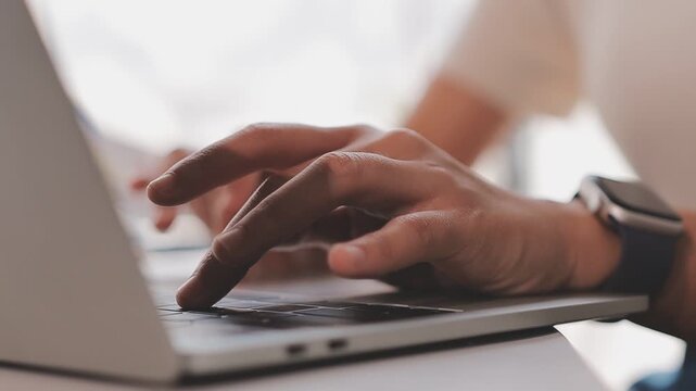Closeup of the hands of a receptionist typing and sending emails while working in an office alone. One secretary doing admin and writing reports while organizing a schedule for her manager at work