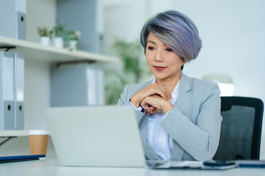 portrait of Asian senior businesswoman with laptop in office.