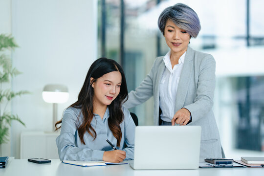 Career coach teaching female trainee at office desk for business development and workplace success guidance