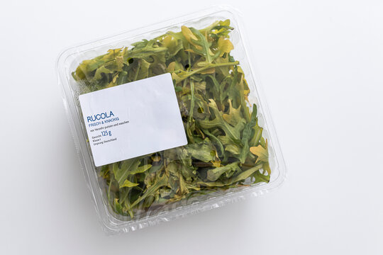 Spoiled prepackaged arugula past its expiration date in a container