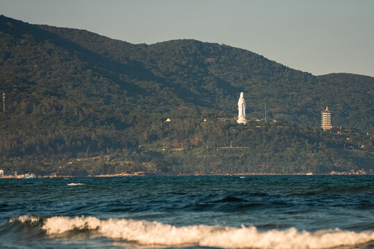 Lady Buddha statue and Linh Ung Pagoda above coastline with sea waves and mountains in Da Nang, Coastal landscape with ocean waves and Son Tra Peninsula, Danang Vietnam
