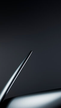 Abstract closeup of smooth metallic curved surface on dark background