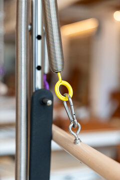 Pilates reformer spring and tension hook on wooden exercise bar