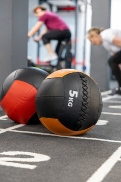 Five-kilogram medicine balls anchoring a gym workout scene