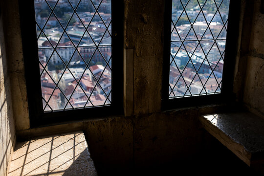 Historic leaded glass windows in a stone interior casting geometric shadows in sunlight