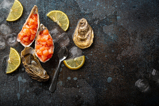 Salmon tartare in oyster shells with lemon wedges and ice cubes