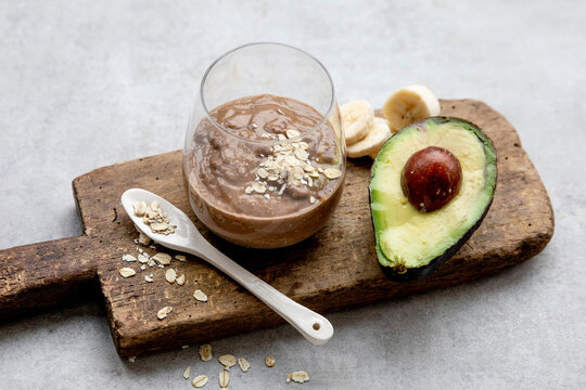 Avocado chocolate shake with banana and oats on wooden board