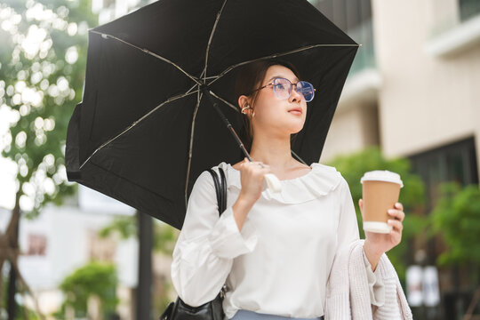 Business asian woman holding UV protection umbrella on sunny day confidence smiling