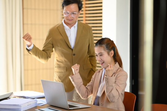 Business Colleagues Celebrating Success on Laptop in Office