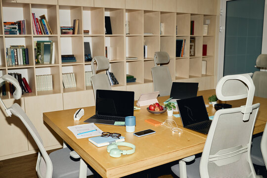 Coworking office table with laptops and stationery representing modern collaborative workplace. Useful for corporate business websites, coworking advertising and team workflow articles