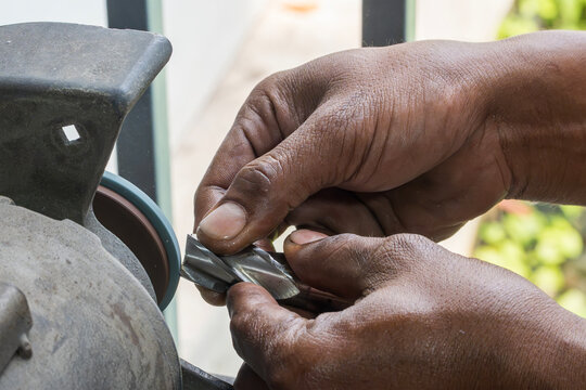 Flat nose end mill tool regrinding and sharpening process by a skilled operator with an abrasive wheel