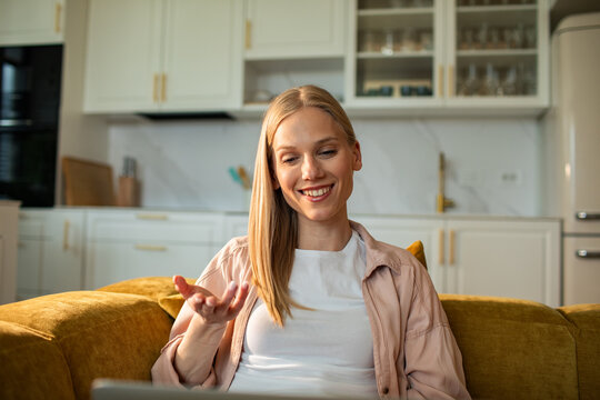 Smiling woman on video call in home kitchen