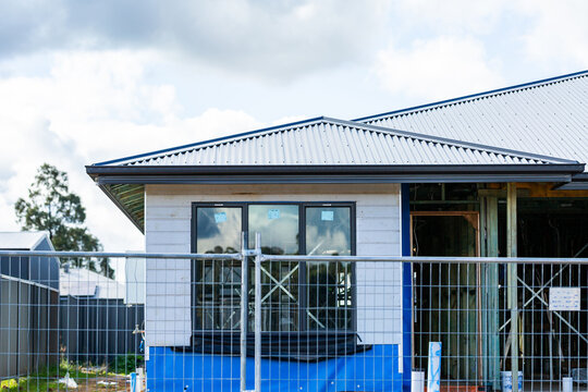 Temporary fencing around construction worksite with house being built